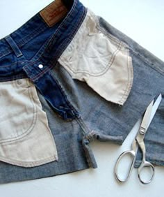 pair of scissors and jean shorts laying next to each other