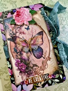 a card with an image of a butterfly and pink flower on it that says be creative