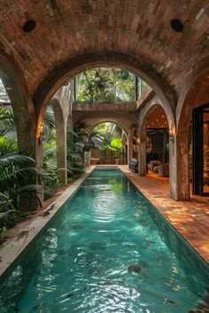 an indoor swimming pool in the middle of a brick building with arched doorways leading to it