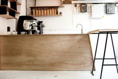 a coffee shop with shelves, counter and stools