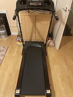 a treadmill is sitting on the floor in front of a door and some toys