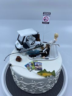 a wedding cake with a car on top and a sign that says no fishing allowed