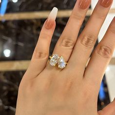 a woman's hand with two engagement rings on it