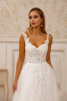 a woman in a white wedding dress is posing for the camera with her hand on her hip