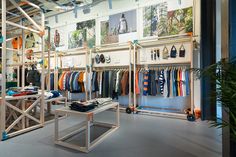 the inside of a clothing store with clothes on racks