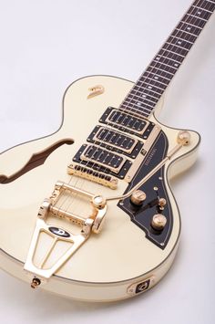 a white electric guitar with gold hardware on it's neck and pickguards