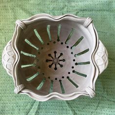 a white bowl sitting on top of a green table cloth