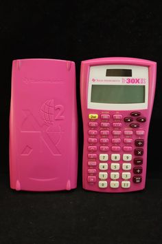 a pink calculator sitting on top of a black table