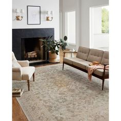 a living room filled with furniture and a rug on top of a hard wood floor