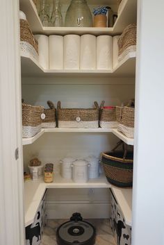 an organized pantry with white shelves and baskets