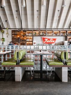 the interior of a fast food restaurant with green leather seats and shelves filled with soda bottles