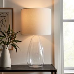 a table with a lamp and vase on it