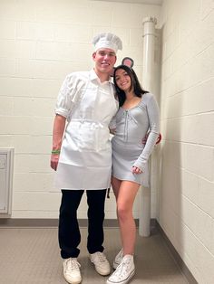 a man and woman dressed up as chefs posing for a photo in front of a wall