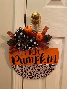 an orange and black door hanger that says hey there pumpkin with leopard print ribbon