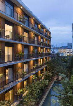 an apartment building with many balconies and plants on the balconies at night