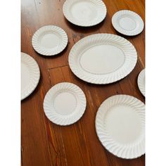 white dinner plates laid out on a wooden floor