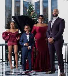 a family posing for a photo in front of a christmas tree with their son and daughter