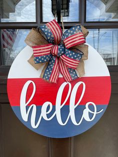 a red, white and blue door hanger with the word hello painted on it