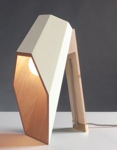 a lamp that is sitting on top of a table next to a white wall and floor