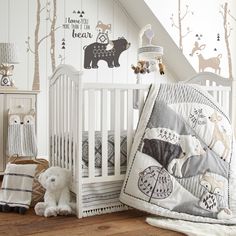 a baby crib in the corner of a room with white walls and wooden floors