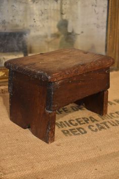 an old wooden bench sitting on top of a rug in front of a mirror with writing underneath it