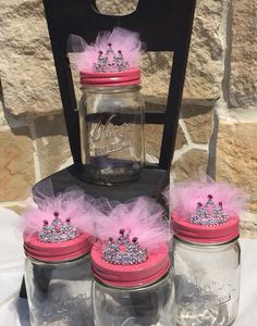 four mason jars with pink and silver crowns on them