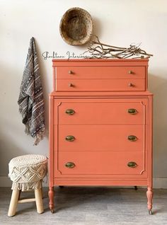 an orange dresser sitting next to a white wall