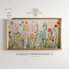 a painting hanging on the wall next to a frame with flowers and plants painted on it