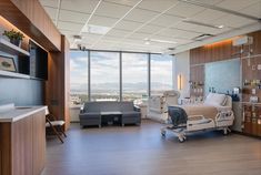 an empty hospital room with medical equipment on the floor and large windows in the background