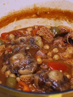 a pot filled with stew and vegetables on top of a stove