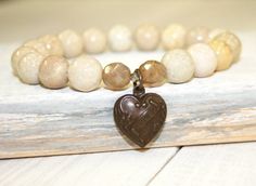 "Creamy River stone Stretch Bracelet with Heart Charm This River stone bracelet has an etched, heart shaped charm that says \"I love U\". The cream beads are 10mm. The charm is nestled in between 2 opalescent Czech glass beads. This earthy stretch/stack bracelet is a really versatile piece. It can be worn with other stacking bracelets, or leather wrap bracelets, but makes a simple statement when worn by itself. This is a medium size bracelet, measuring 7.25\". Your bracelet will be shipped in a Cream Stone, Life Jewelry, Bracelet With Heart, Bracelet Heart, River Stones, I Love U, Bracelet Gemstone, Leather Wrap Bracelet, Organza Gift Bags