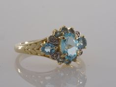 This beautiful vintage 1990's ring features a thick 14k gold band with very nice Blue Topaz gemstones and 4 small Natural Diamond accents. This ring will be shipped in a brand new gift box. RING SIZE: 6.75 (Sizable by your local jeweler) Metal: 14k yellow gold with white gold accents (Verified by acid test) Gemstone: 1 Oval Cut Blue Topaz (6.6mm x 5.1mm) &2 pear Cut Blue Topaz(3.2mm x 4.6mm) & 6 round cut Blue Topaz(approx. 2.0mm x ea) 4 round cut Natural Diamonds (approx. 1.6mm x ea ) W Vintage Yellow Gold Rings With Blue Topaz, Vintage Yellow Gold Blue Topaz Rings, Vintage Blue Multi-stone Ring, Heirloom Blue Multi-stone Cluster Ring, Blue Gemstone Cluster Ring Vintage Style, Vintage Blue Gemstone Cluster Ring, Gold Heirloom Style Blue Topaz Birthstone Ring, Heirloom Gold Blue Topaz Birthstone Ring, Heirloom Gold Birthstone Ring With Blue Topaz