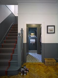 there is a hallway with grey walls and red steps