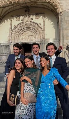 a group of people standing next to each other in front of a building