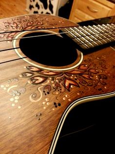 a close up of an acoustic guitar on a table