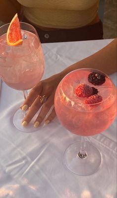 two cocktails sitting on top of a table next to each other