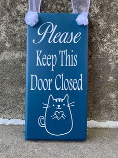 a blue sign that says please keep this door closed with a cat drawn on it