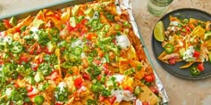 a tray filled with nachos and salsa next to a plate of guacamole