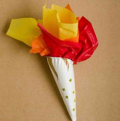 a paper cone with red and yellow tissue wrapped around it