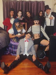 a group of people dressed up in costume posing for a photo with one person on the floor