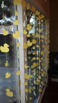 some yellow ducks hanging from the side of a window