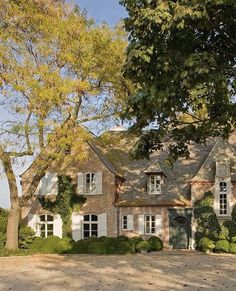 a large brick house surrounded by trees and bushes