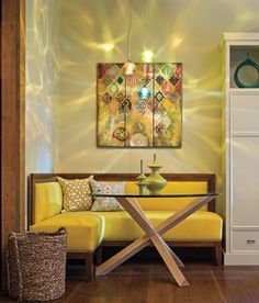 a living room filled with furniture and a painting on the wall over a glass table