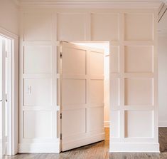 an open door in a white room with wood flooring and hard wood planks