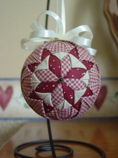 a red and white ornament with a bow on it