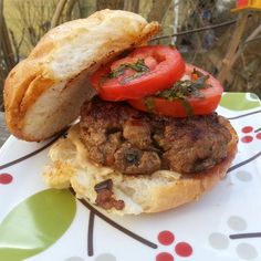 a hamburger with tomatoes and meat on it