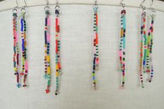 multicolored beaded necklaces hanging from a lamp shade