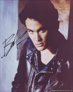 an autographed photo of a young man wearing a leather jacket