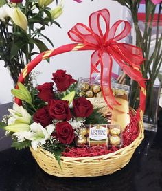 a basket filled with red roses and chocolates