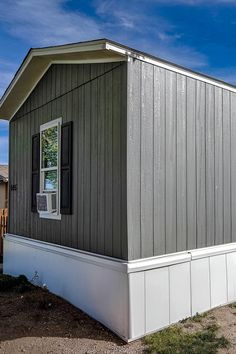 a small gray house with white trim and windows